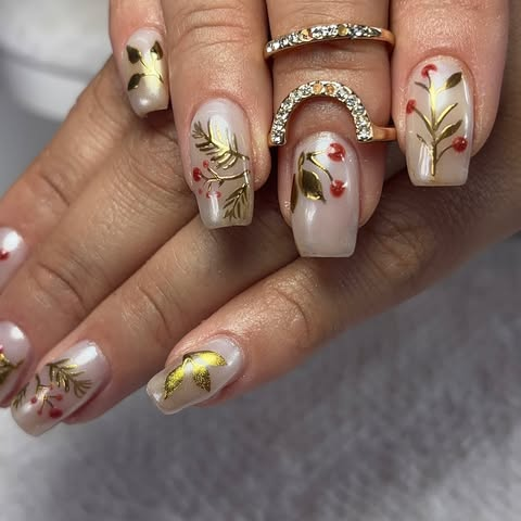 Nail art floral dourada sobre base leitosa